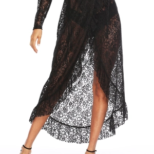 Détail de robe maxi en dentelle noire transparente avec fente et ourlet volanté