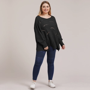 Detail view of black knit sweater with hollow out design and biker skinny jeans