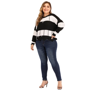 Detail shot of black and white striped knit sweater featuring unique tassel hem design