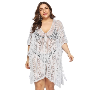 Detail of white crochet beach cover-up featuring semi-transparent knit texture and V-neck