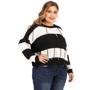 Black and white striped oversized knit sweater with tassel details and irregular hem
