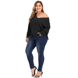 Detail of V-neck knit sweater featuring distressed ripped hem and black off-shoulder design