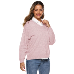 Detail of soft pink V-neck knit sweater layered over a white shirt for a casual look