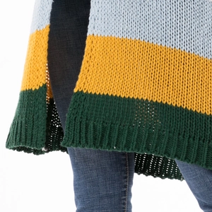 Gros plan du cardigan en maille tricolore avec texture épaisse et fente latérale
