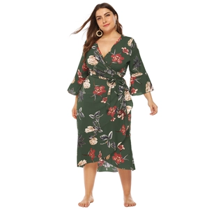 Detail of plus size wrap dress featuring V-neckline and dark green floral print fabric