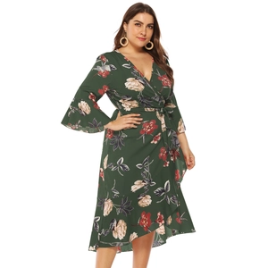Detail of floral print plus size dress showing ruffled hem and cross tie waist design