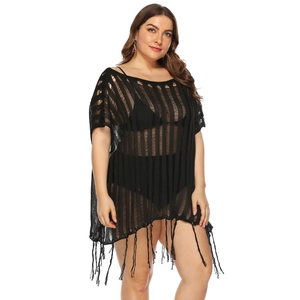 Detail of black crochet beach cover-up featuring hollow vertical stripes and long tassels