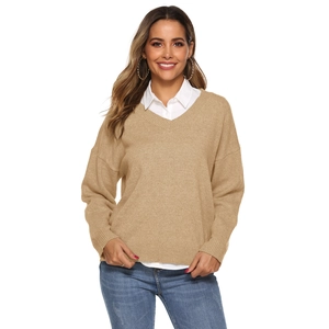 Detail of khaki V-neck knitted sweater layered with a white shirt and denim jeans