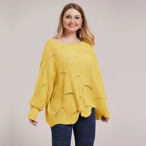 Detail of loose yellow oversized knit sweater with unique semi-circle cutout textures