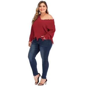 Close-up of wine red oversized V-neck sweater featuring distressed hem and ripped edges