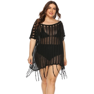 Detail of black crochet beach cover-up featuring hollow-out patterns and long fringe tassels