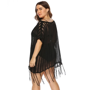 Detail of black crochet beach cover-up featuring sheer vertical stripes and long tassels