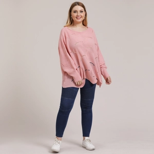 Close-up of pink oversized knit sweater featuring intricate hollow wave patterns and loose fit