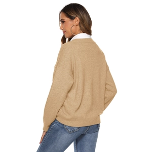 Back view of a khaki V-neck knit sweater layered over a white shirt and blue jeans