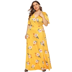 Detail of plus size yellow floral wrap maxi dress with V-neck and tie-waist design