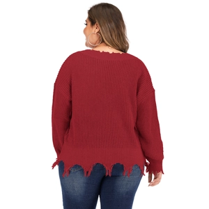 Detail of burgundy thick knit sweater with distressed frayed edges and ripped hemline