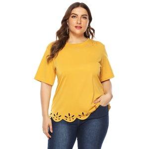 Detail of laser-cut petal patterns on the hem of a mustard yellow plus size t-shirt