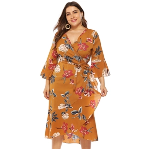 Detail of the ruffle hem and floral print on a yellow plus size wrap dress for women