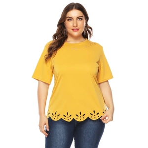 Detail of yellow plus size t-shirt featuring laser-cut floral patterns and scalloped hem