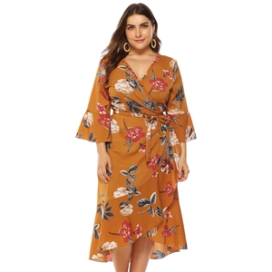 Detail of floral wrap plus size dress with ruffle hem and bell sleeves in yellow