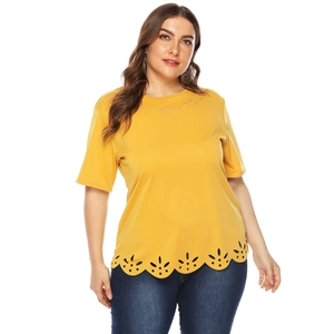 Detail of laser-cut eyelet embroidery and scalloped hem on ginger yellow plus size T-shirt