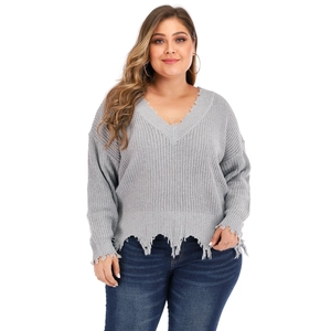 Detail view of V-neck plus size gray sweater with distressed ripped fringe on the hem