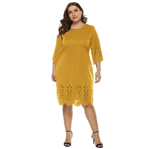 Detailed view of mustard yellow laser-cut hollow floral pattern on dress sleeves and hemline