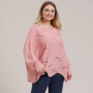Detail of pink knit sweater with cutout patterns and irregular hemline on a model