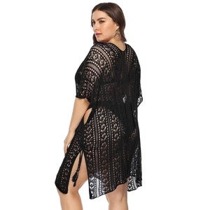 Detail of black crochet lace beach cover-up featuring hollow patterns and side tassel drawstrings