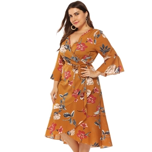Detailed view of ruffle hem and floral pattern on plus size mustard wrap dress