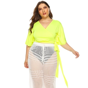 Detail view of neon yellow wrap top with crochet white hollow mesh wide leg pants