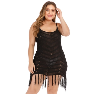 Detail of black crochet beach dress with hollow V-pattern knit and long fringe tassels
