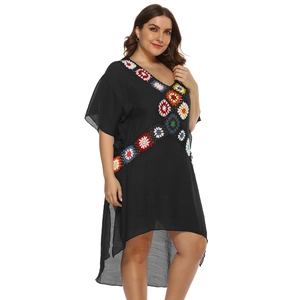 Close-up of colorful crochet flower trim and V-neck detail on black beach dress