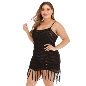 Close-up of black crochet knit texture with fringed hem and mesh details on beach dress
