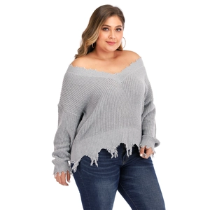 Detail shot of distressed hem and frayed edges on light grey V-neck knit sweater