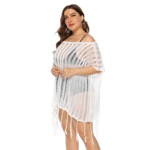 Detail of white crochet hollow-out beach cover-up featuring fringe hem and plus size fit