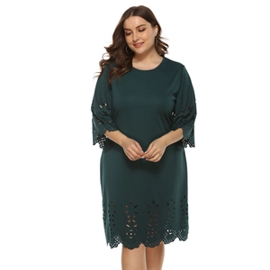 Detail of laser-cut floral patterns on sleeves of dark green plus size A-line dress