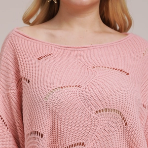 Detail of pink knitted sweater with circular hollow out patterns and textured crochet weave