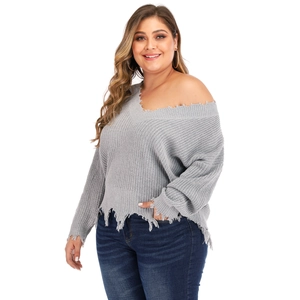 Detail of gray V-neck plus size knit sweater featuring distressed ripped hem and soft texture
