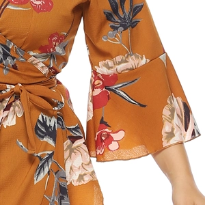 Detail of floral wrap dress with waist tie and bell sleeves in mustard yellow fabric
