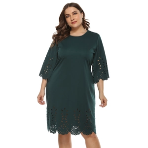 Detail of dark green plus size dress featuring intricate laser-cut hollow floral patterns