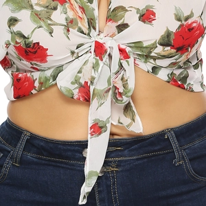 Close-up of floral chiffon crop top featuring front tie knot and red rose print