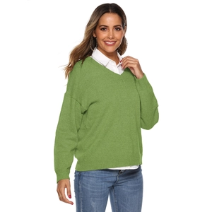 Detail of olive green V-neck knitted sweater with ribbed cuffs and loose fit style