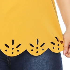 Detail of scalloped laser-cut floral hem on a mustard yellow short sleeve top
