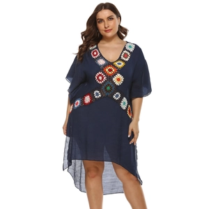 Detail of colorful crochet flowers on the neckline of a navy blue plus size beach dress