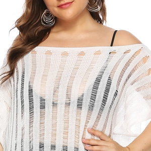 Close-up of white crochet beach cover-up featuring off-shoulder cut and vertical textures