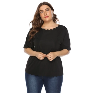 Detail of plus size black short sleeve top featuring elegant scalloped neckline and hem