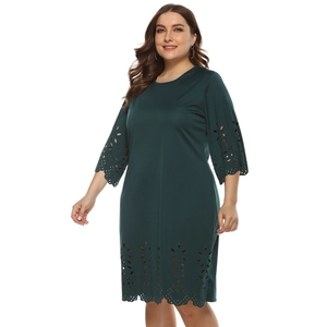 Detail of the laser-cut floral pattern on the sleeves and hem of the dark green dress