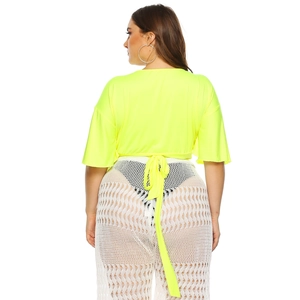 Plus size neon yellow V-neck crop top with tie-back paired with white crochet pants