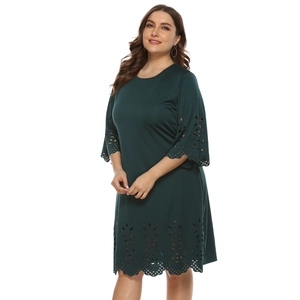 Detail of laser-cut floral patterns on dark green dress sleeves and hemline